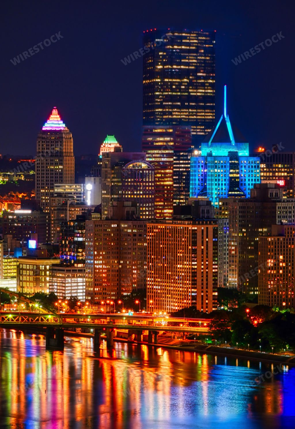 A vertical shot of the skyline of Pittsburgh in PA with lights at night