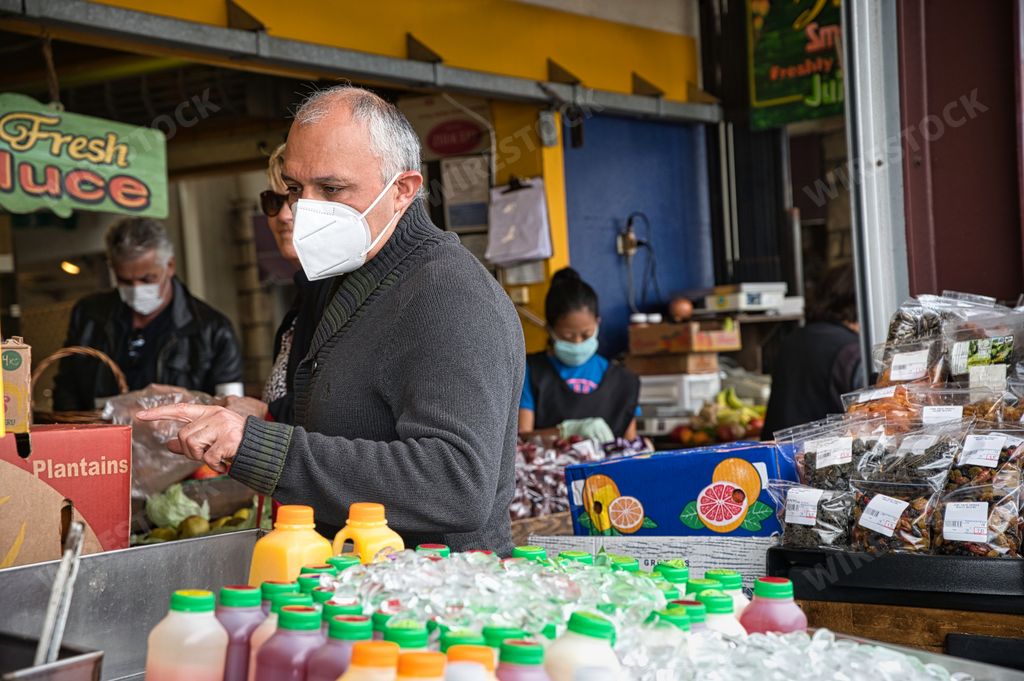 A man shops at the farmers market wearing a face mask during the COVID-19 outbreak.