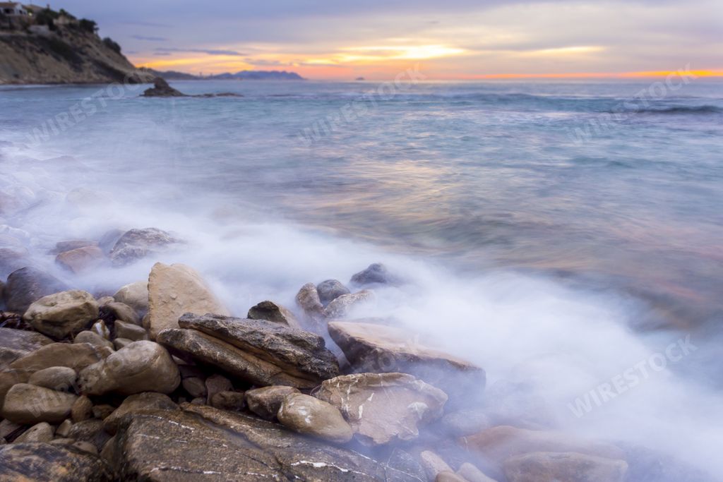 A long exposure shot of the waves of the ocean during sunset