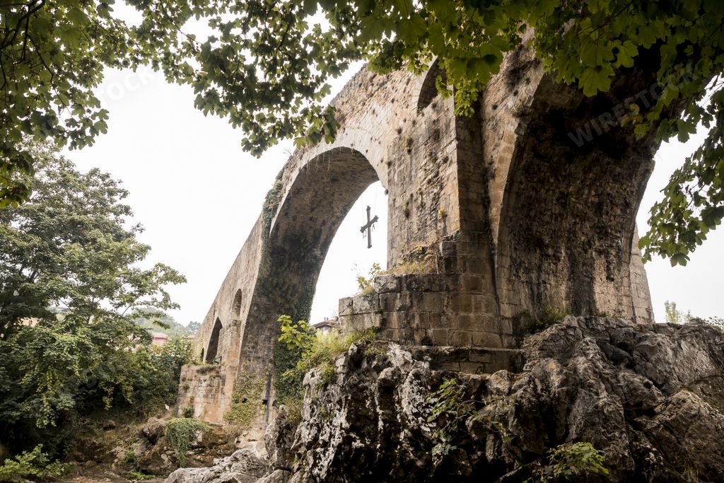 A low angle shot of an old Roman stone bridge in Cangas de Onis over the river in Spain