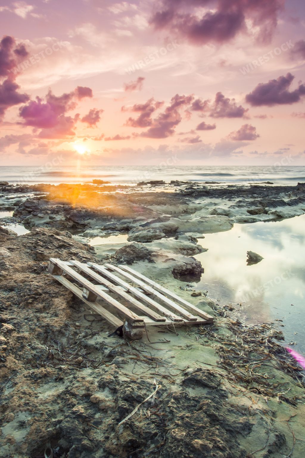 A vertical shot of a dirty coast of the sea under the beautiful sunset sky