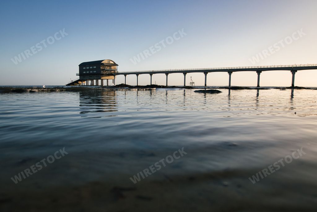 The Bembridge beach and its lifeboat station in the Isle of Wight against the cloudless sky