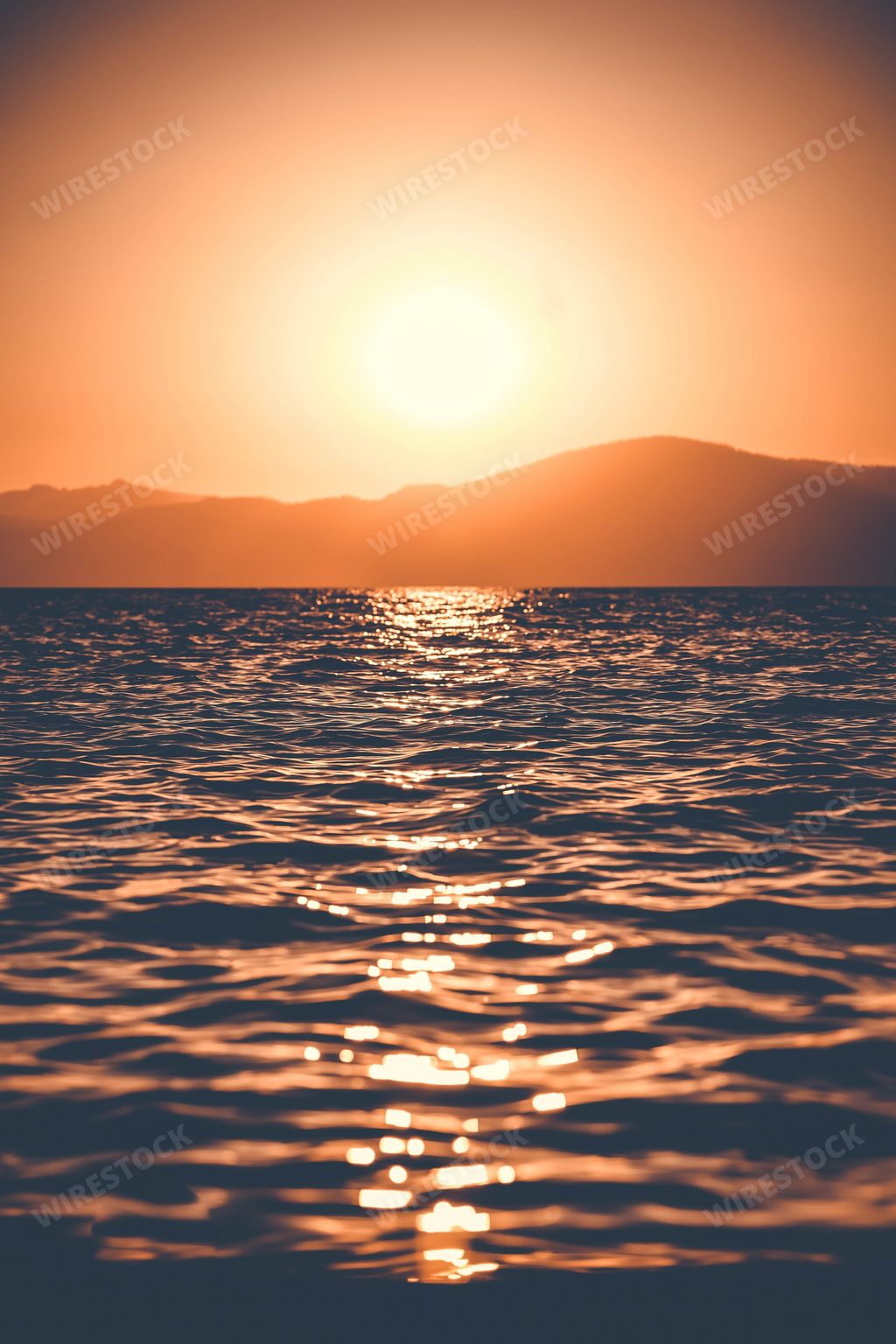 A vertical shot of the breathtaking sunset reflected in the beautiful sea