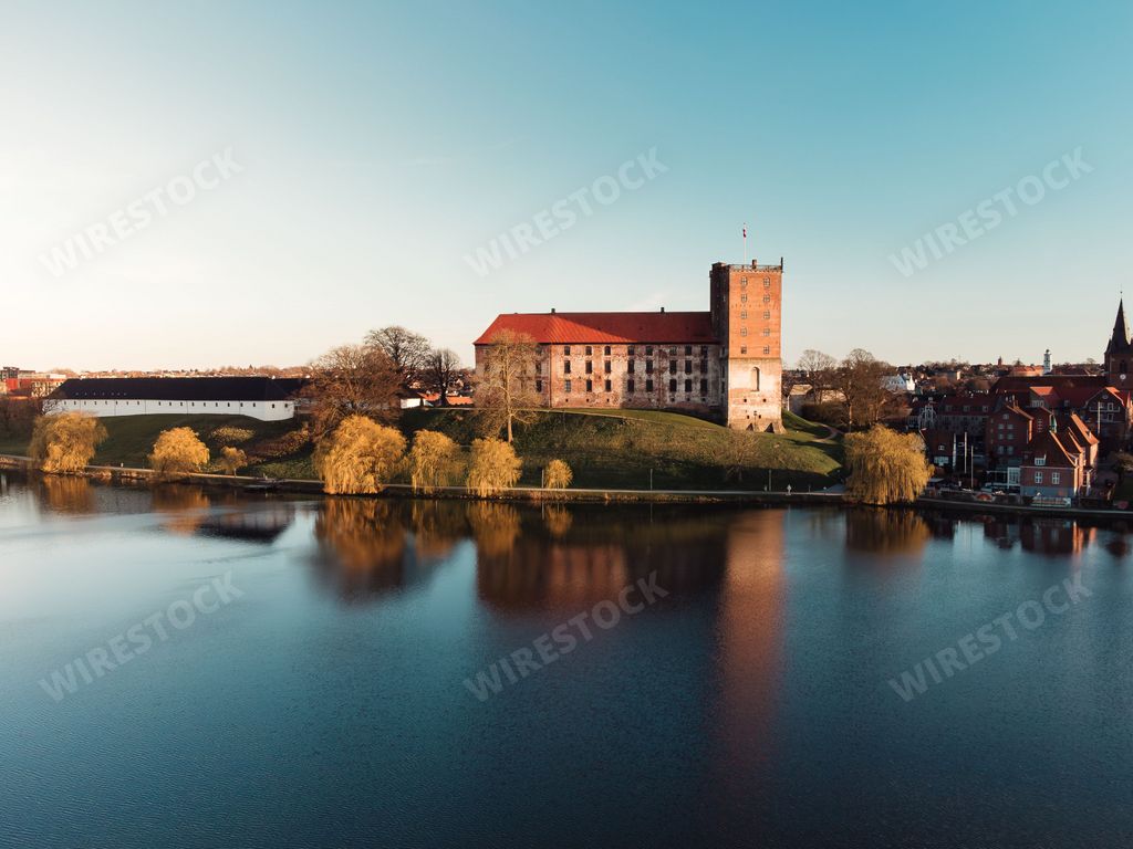 An aerial view of the historic Koldinghus Castle in Kolding, Denmark, with the lake in the foreground