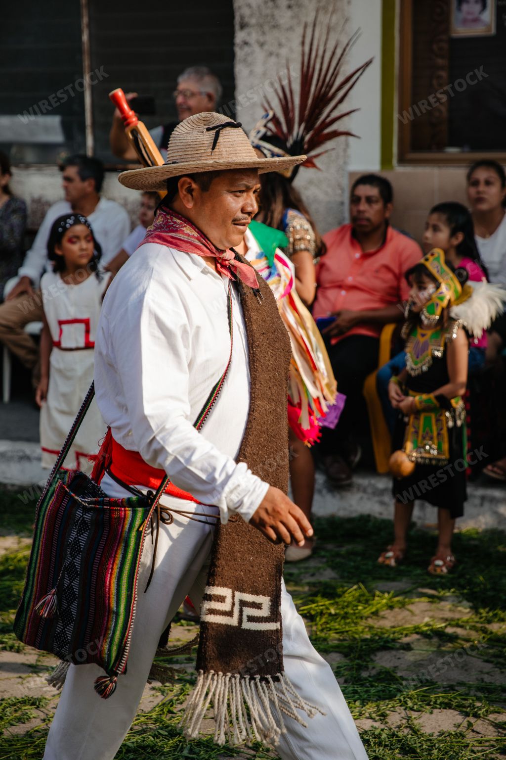 A male in traditional customs perform drum at the annual dancing parade holidays int he street
