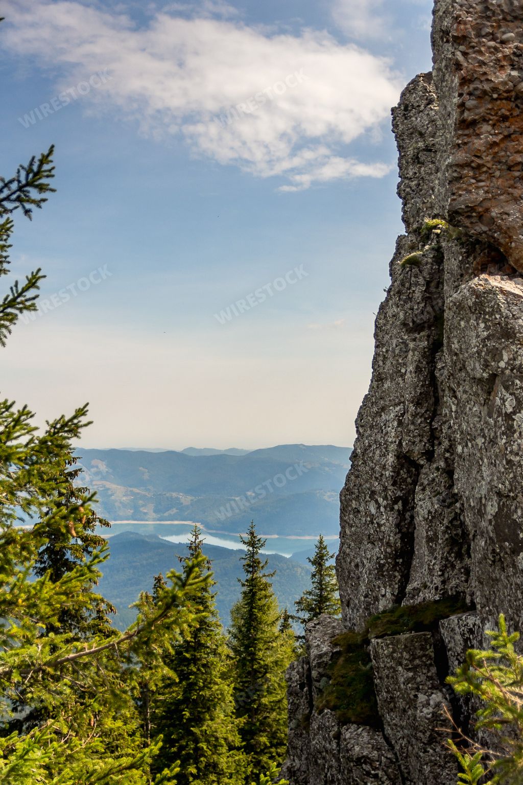 A scenic view of stunning mountains seen through dense forest in Ceahlau mountain, Piatra Neamt, Romania