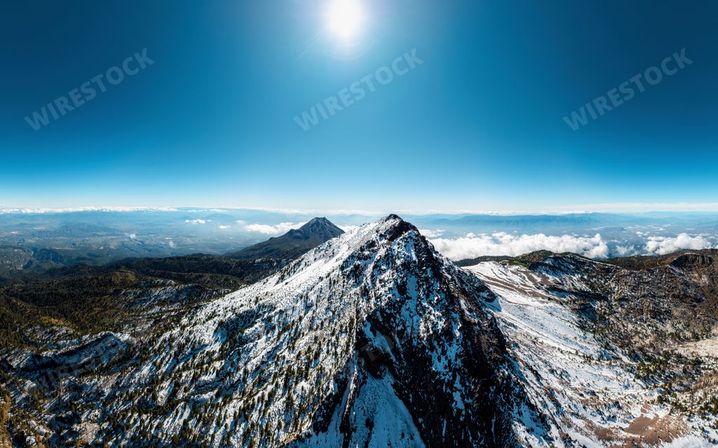 A scenic view of the majestic snow-covered mountain against the blue sky. Nevado de Colima, Mexico