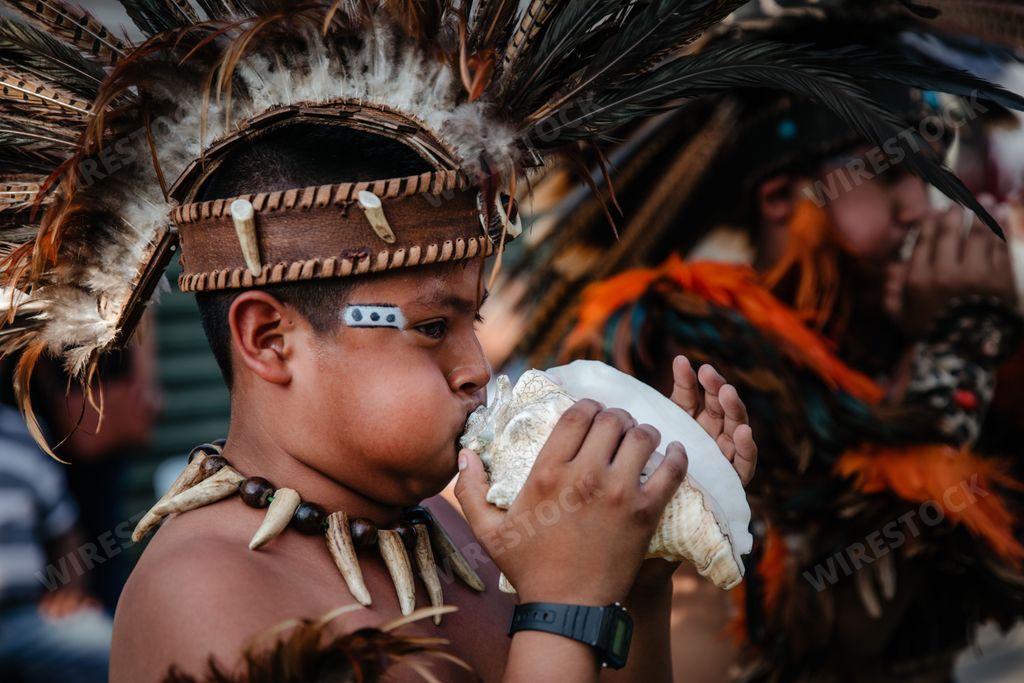 A male with traditional customs wearing native american headdress during the annual dancing parade