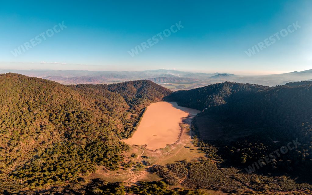 An aerial view of El Calaque dam and laguna El Calaque showing low water levels during dry season in Jalisco, Mexico