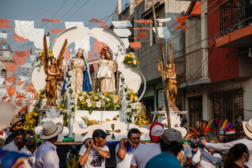 People carry a Jesus statue and the virgin mary during the annual dancing parade for the city holidays