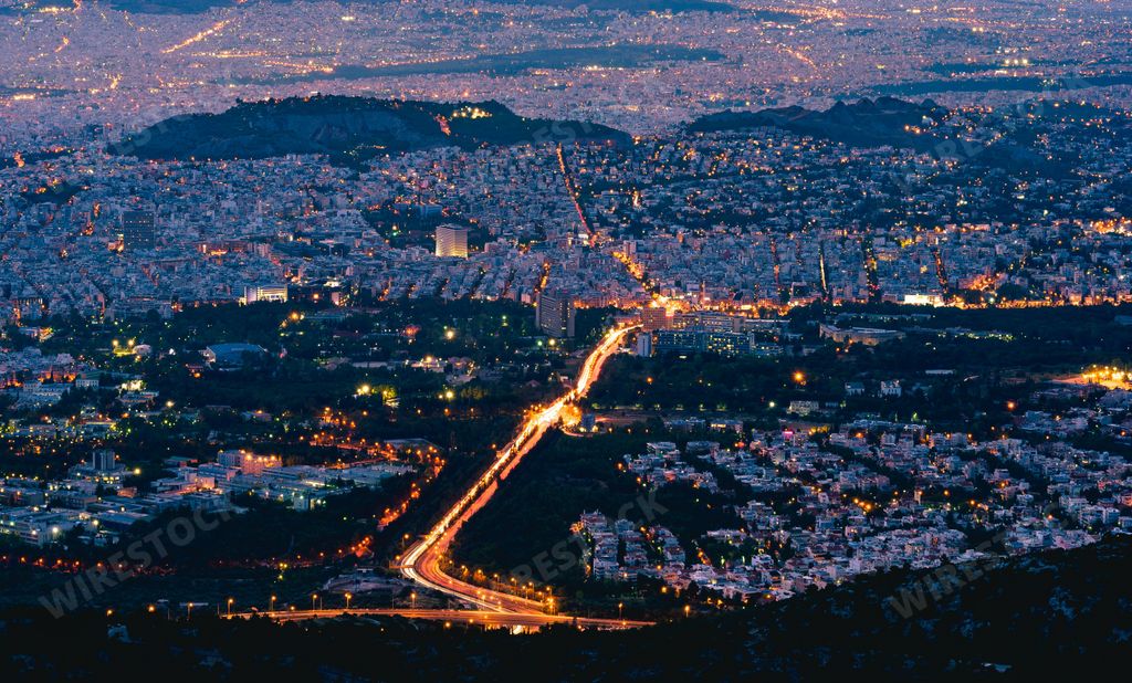 An aerial view of the illuminated skyline with buildings at night in Athens, Greece