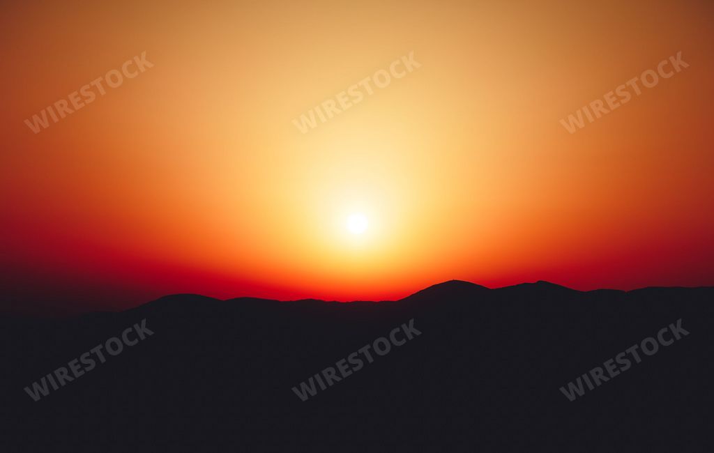 A beautiful shot of a glowing bright sunset sky over mountains in Athens, Greece