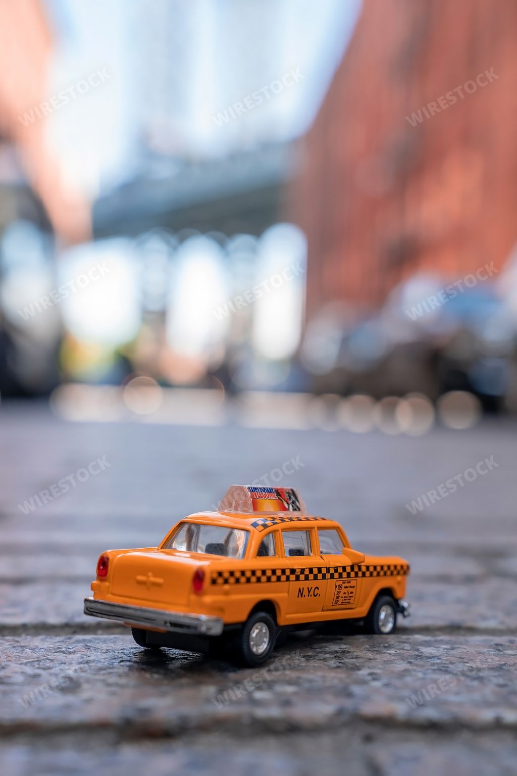 A vertical shot of a classic yellow taxi toy cab on a blurred background