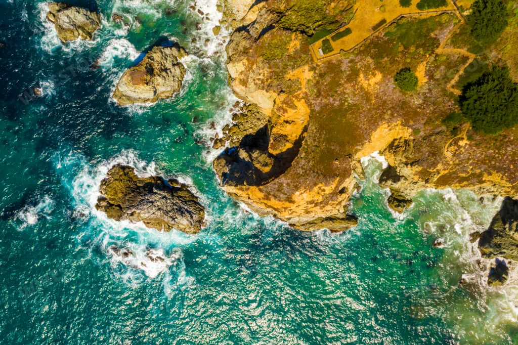 A beautiful scenery of the peaceful sea surrounded by high rocky cliffs in California, USA