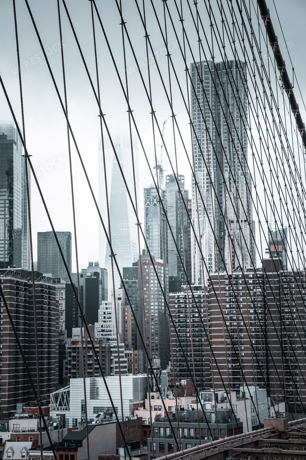 A vertical shot of the beautiful view of the Manhattan island from the Brooklyn Bridge