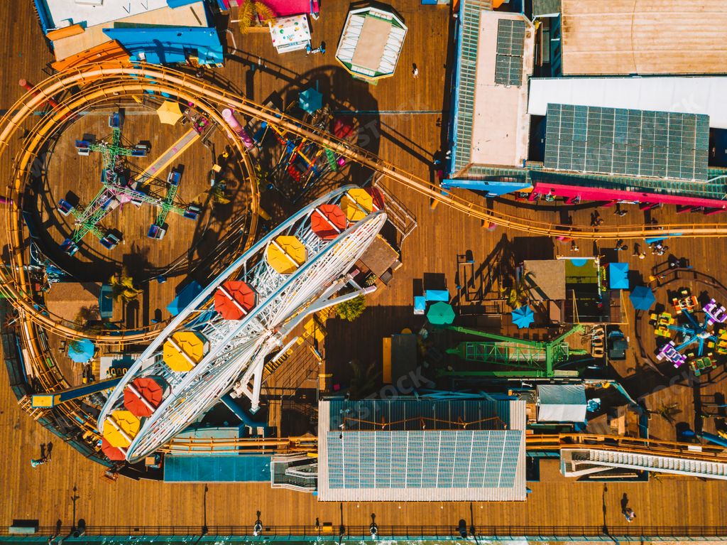 An aerial view of the Santa Monica amusement park with a roller coaster and ferris wheel near Venice beach in Los Angeles, California