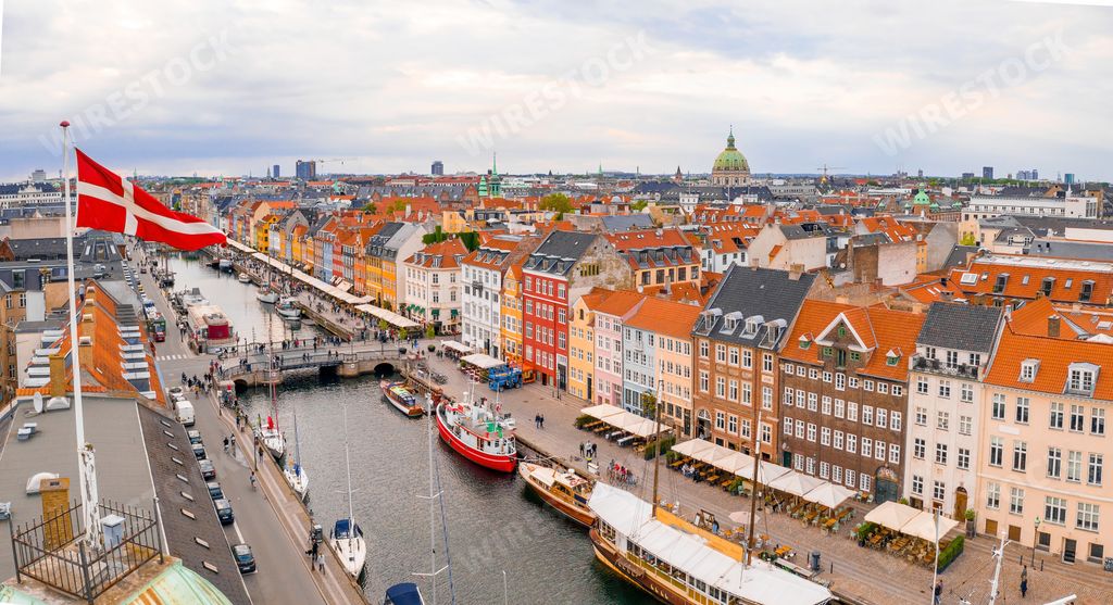 An aerial view of the Danish flag over the cityscape of Copenhagen, Denmark