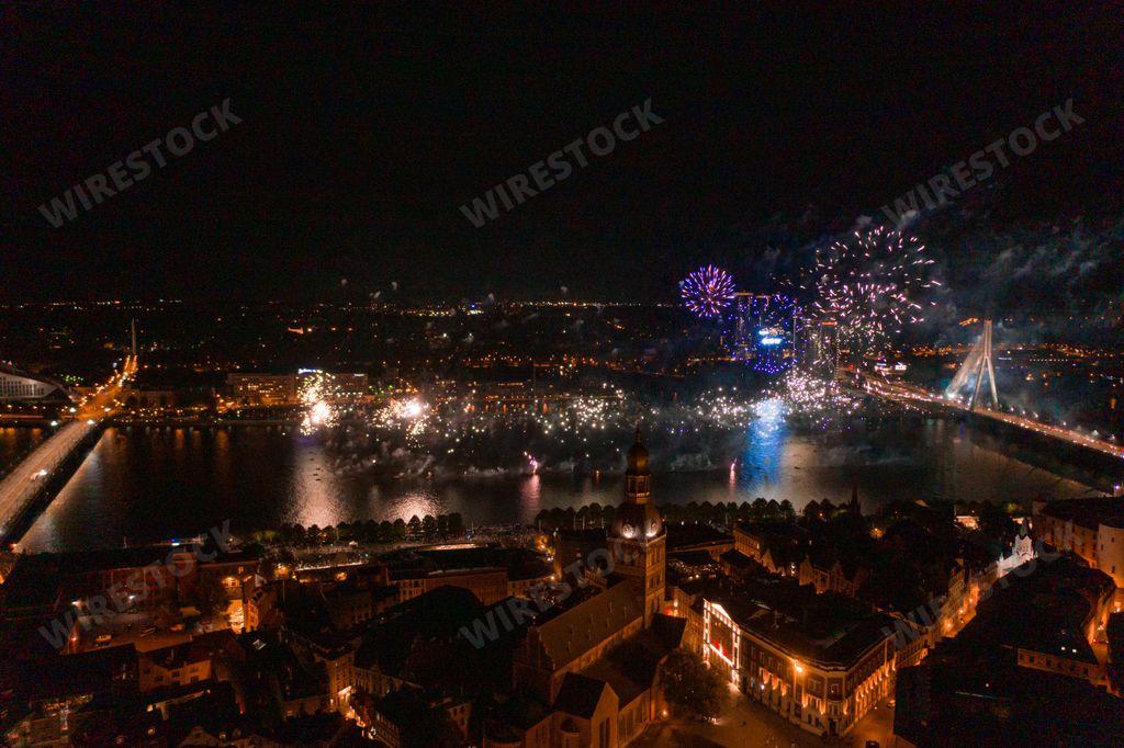 A mesmerizing shot of the cityscape with a beautiful Christmas tree and bright fireworks