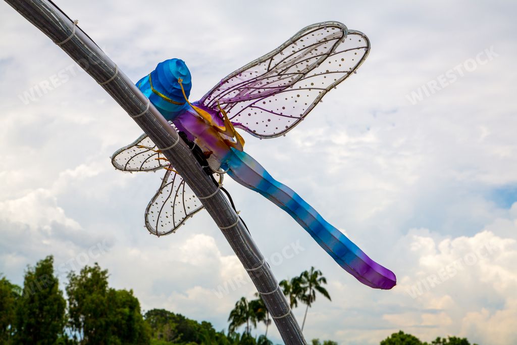A low angle shot of a huge dragonfly sculpture located in the Gardens by the Bay park in Singapore