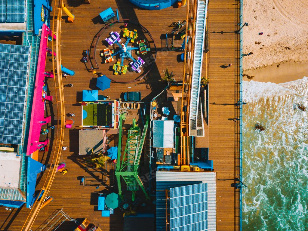 An aerial view of the Santa Monica amusement park with a roller coaster and ferris wheel near Venice beach in Los Angeles, California