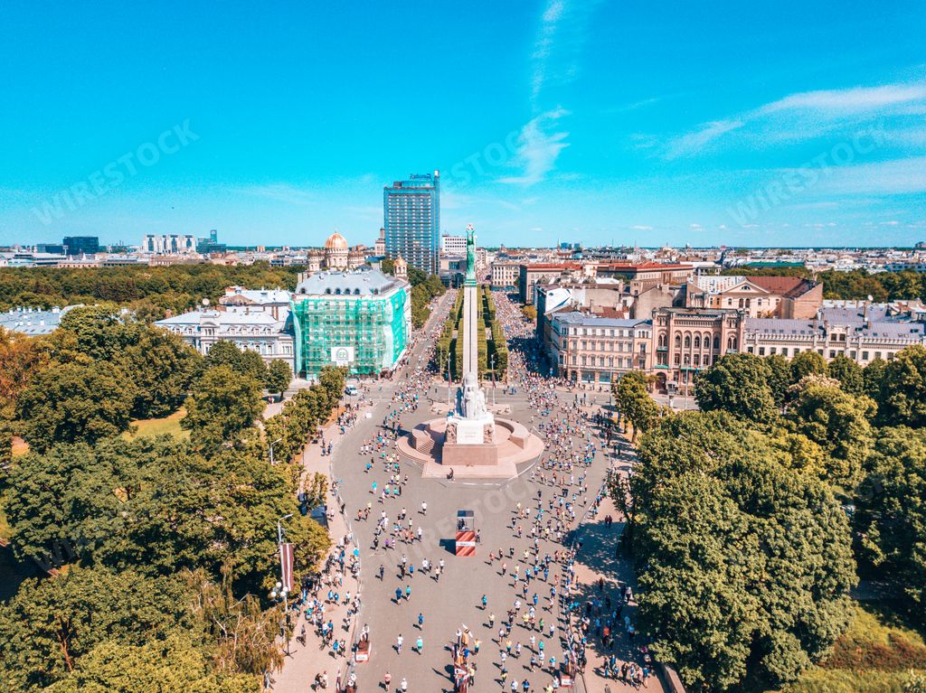 The Freedom Monument surrounded by buildings and greenery under the sunlight in Riga, Latvia