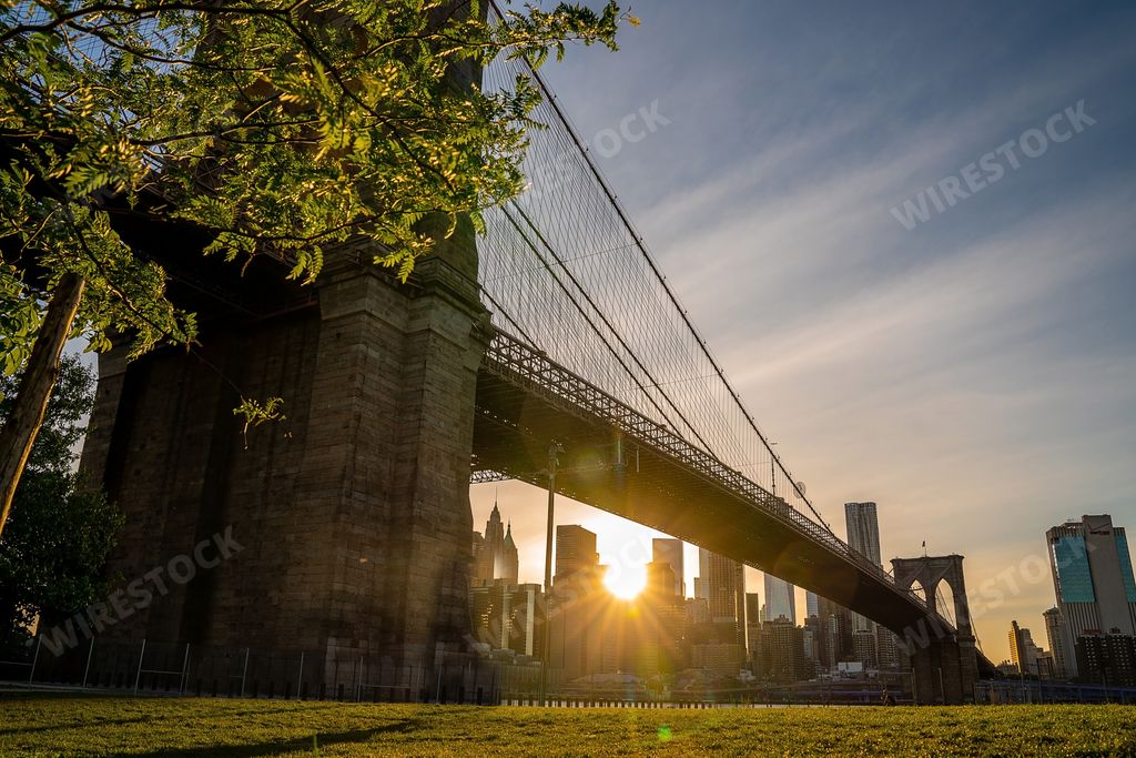 Magical evening sunset view of the Brooklyn Bridge from the Brooklyn park with a lower Manhattan view on the other side of the Hudson River