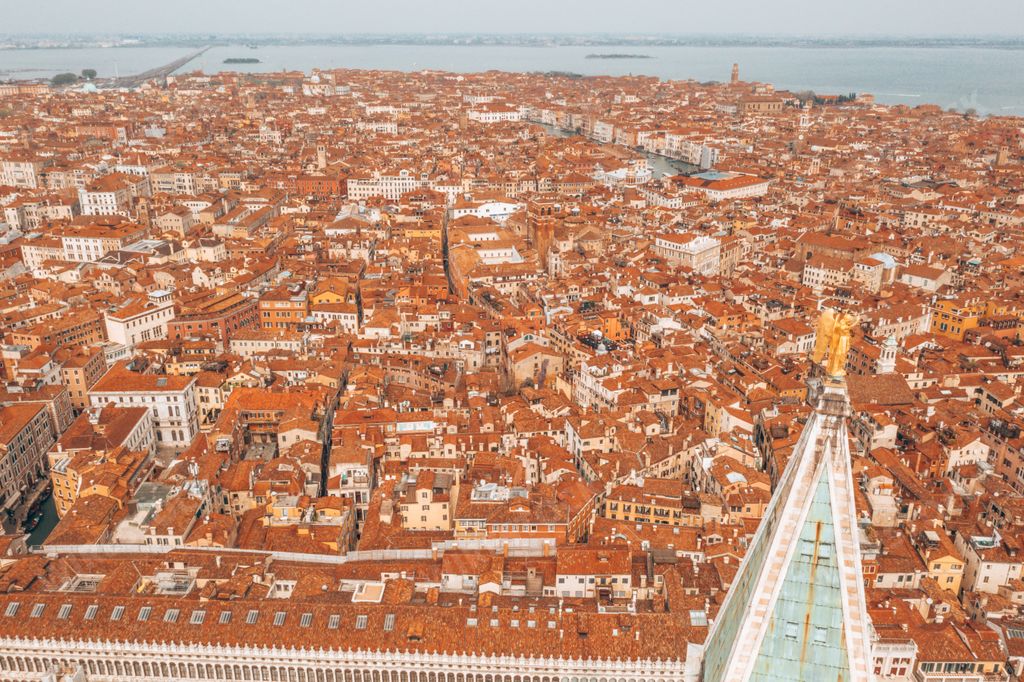 An aerial view of the golden statue of an angel on top of the clock tower in St Mark's Square, Venice, Italy