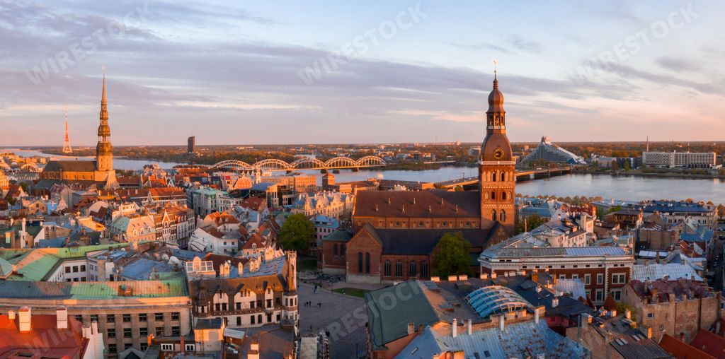 An aerial view of a cityscape with trees and tall buildings at sunset
