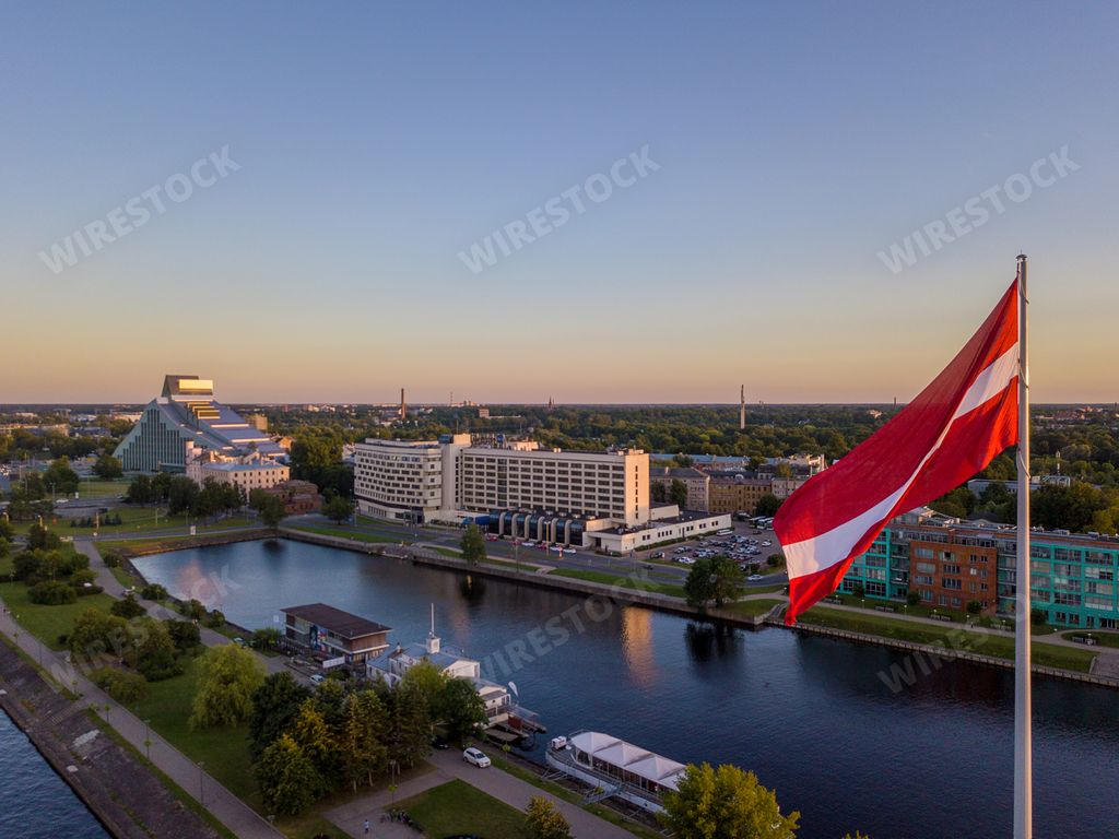 A closeup of the flag of Latvia with AB dam on the background in the evening in Riga, Latvia