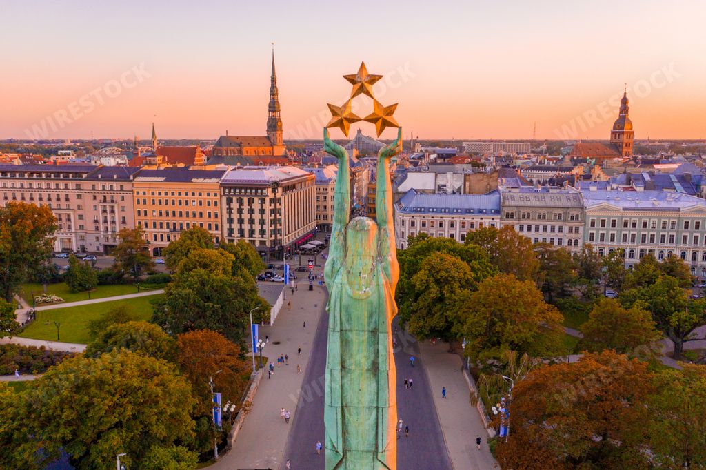 The Freedom Monument surrounded by buildings and trees under the sunlight in Riga, Latvia
