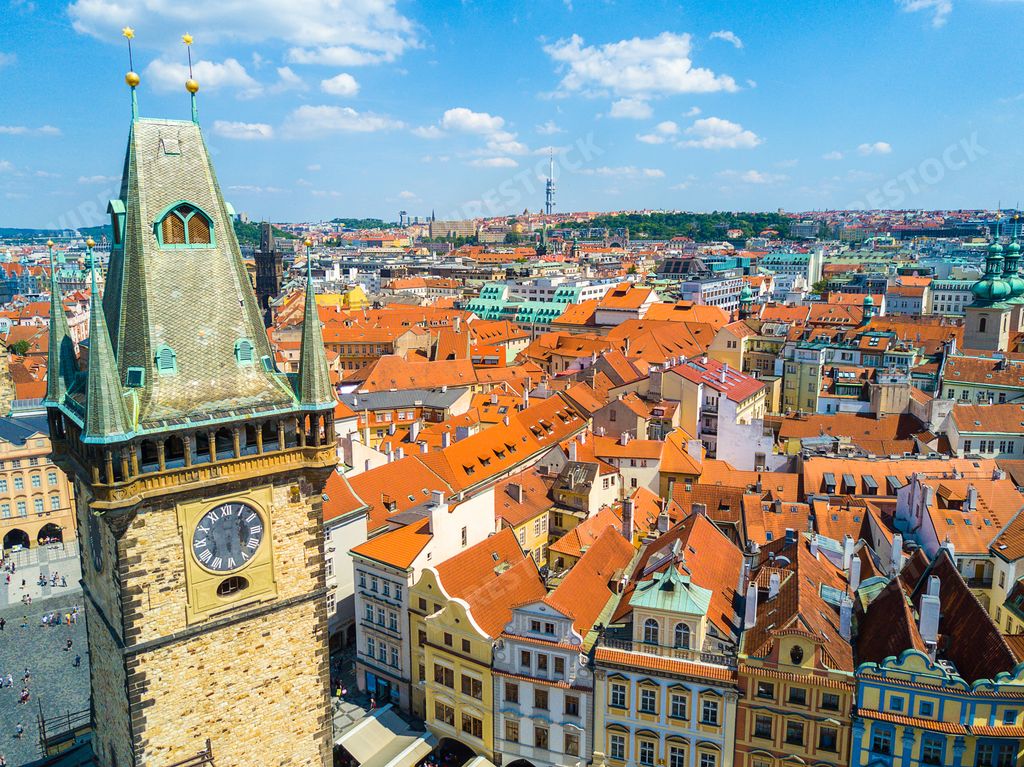 The Church of Our Lady before Tyn surrounded by buildings under a blue cloudy sky in Prague, the Czech Republic