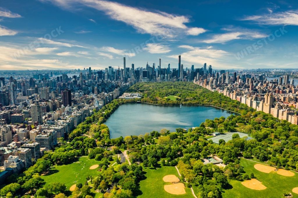 A Central Park in Manhattan, New York, surrounded by skyscrapers, huge pond, and golf fields