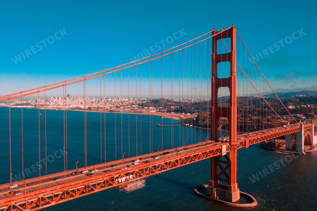 An aerial shot of the Golden Gate Bridge and the San Francisco skyline on a bright day