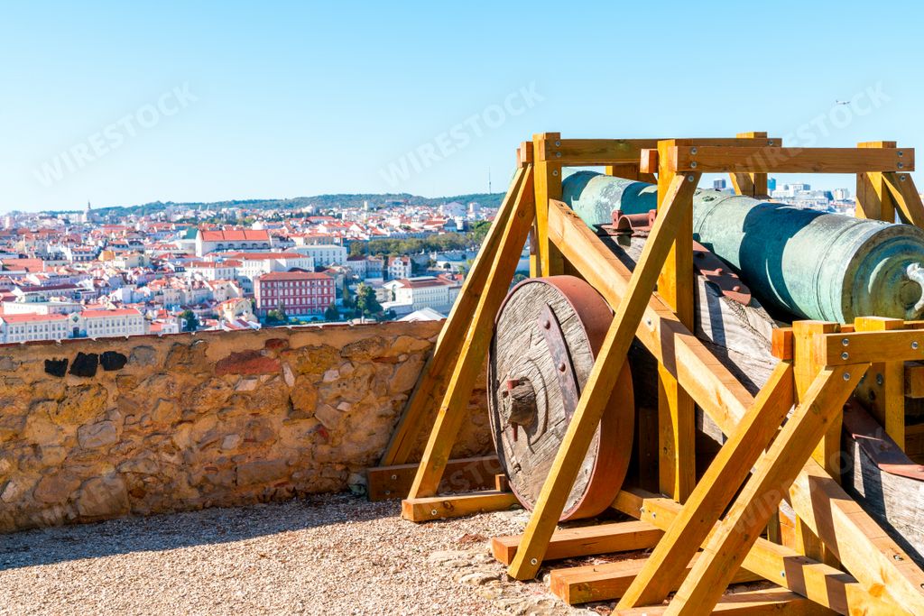 An old cannon at Saint George castle in Lisbon, cityscape on the background
