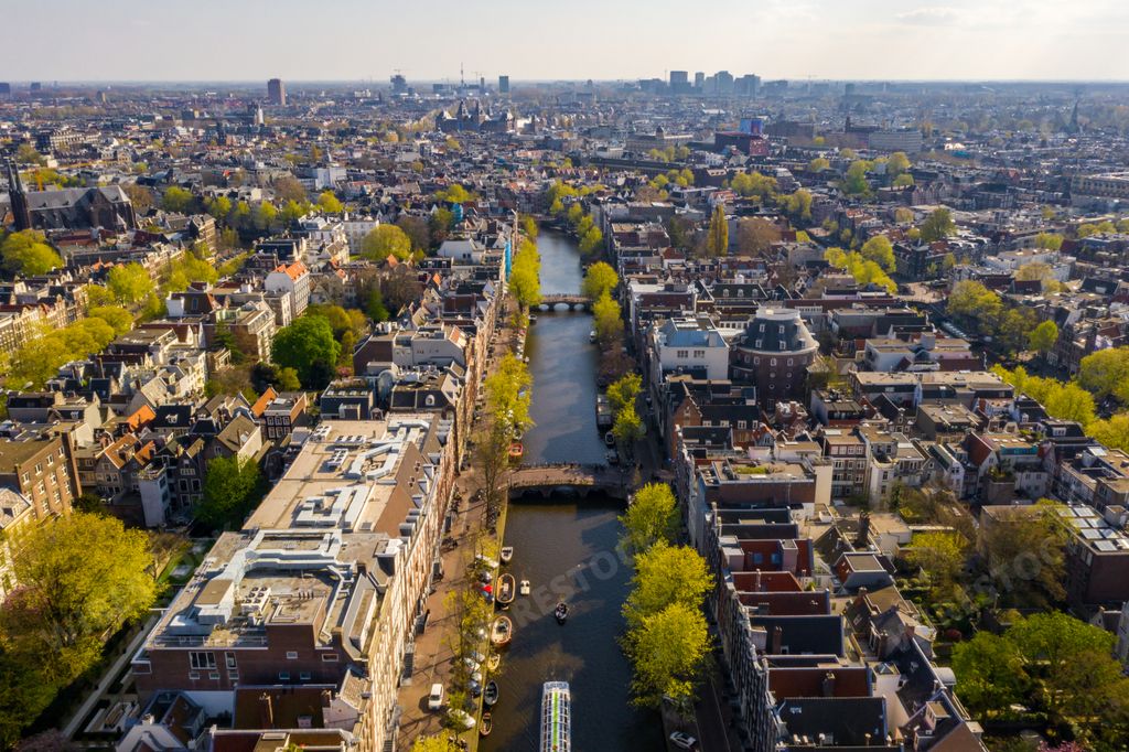 An aerial view of Amsterdam city with many narrow canals, streets and architectures