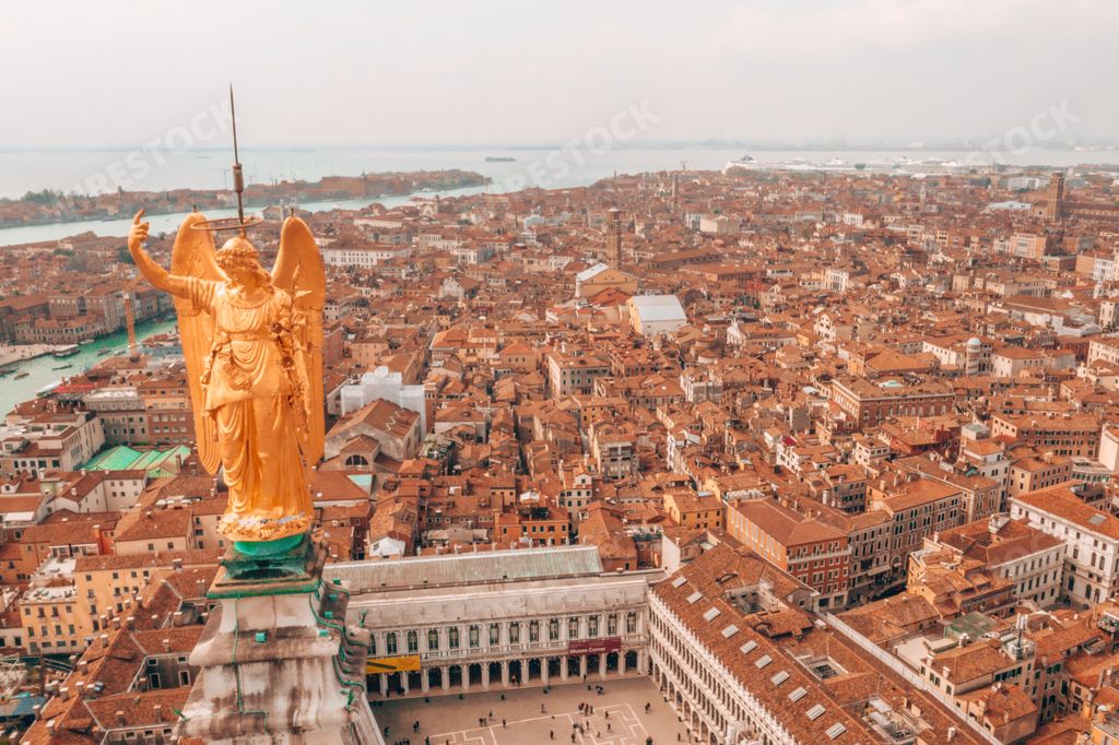 An aerial view of the golden statue of an angel on top of the clock tower in St Mark's Square, Venice, Italy