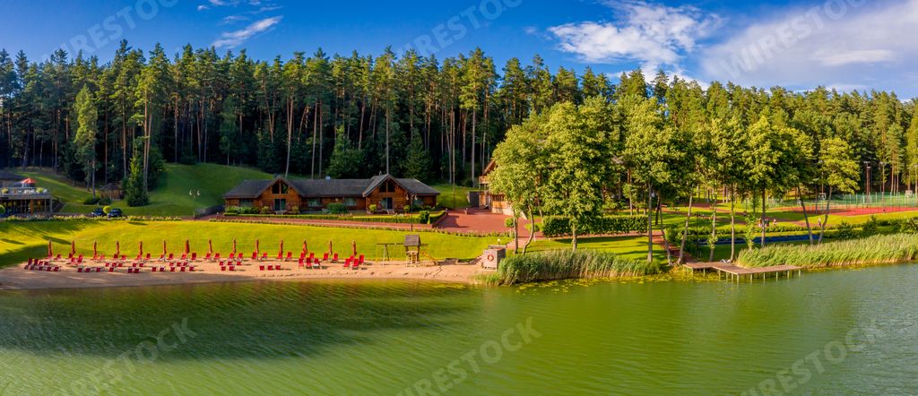 A panoramic shot of a dirty lake surrounded by houses and greenery in the Walchwil village in Canton of Zug, Switzerland