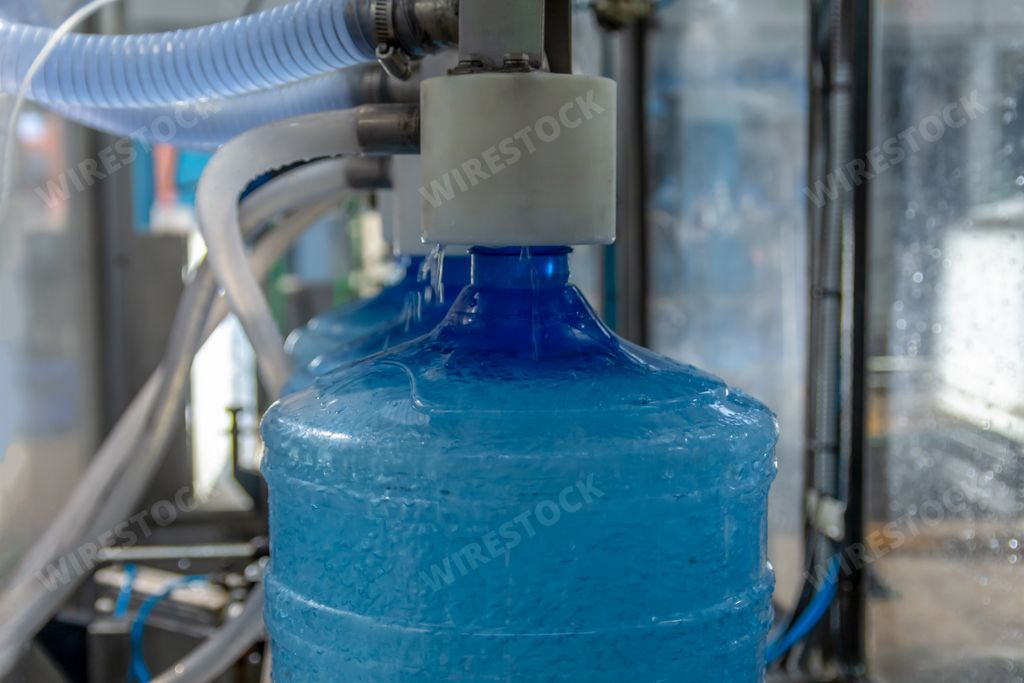 A production line for clean drinking water with tubes in blue plastic bottles
