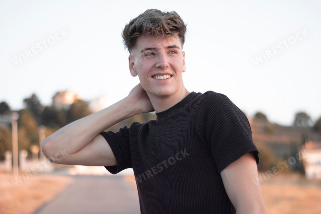 A blonde Spanish man smiling and looking away