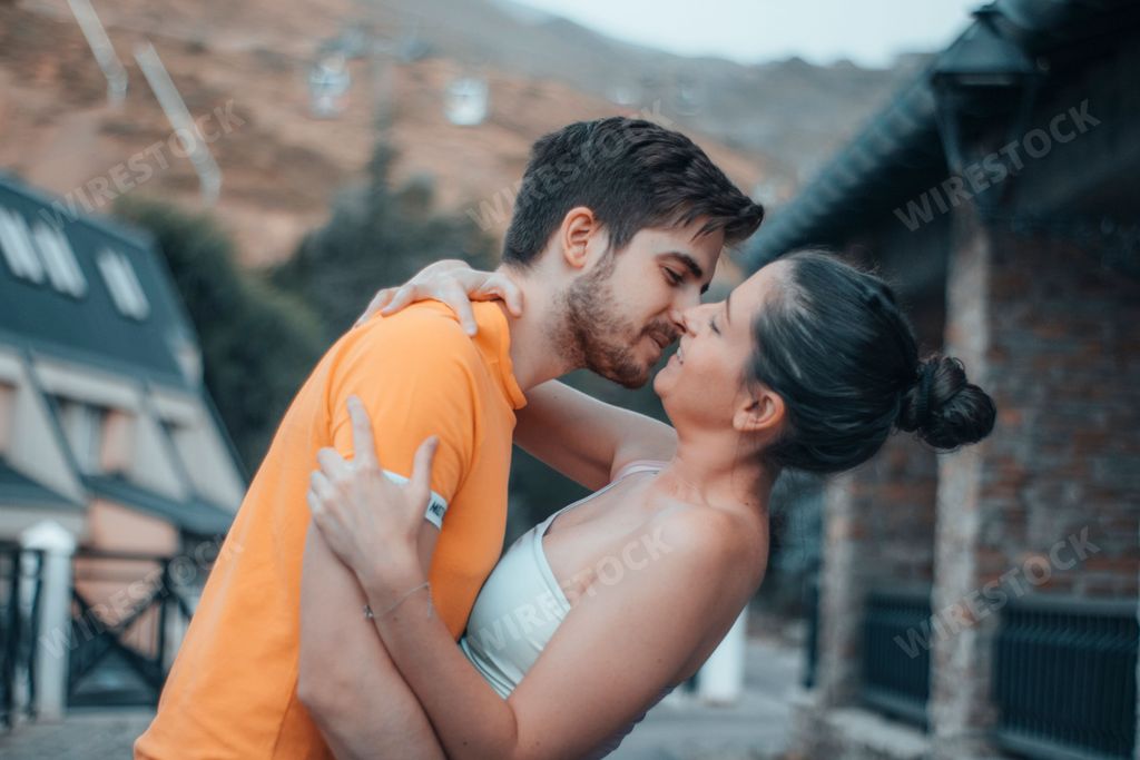 A photoshoot of a young happy couple hugging and kissing each other showing love