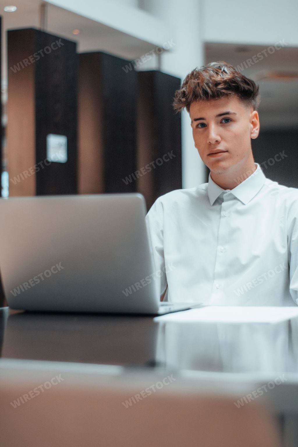 A handsome young business boy working on a laptop in the office