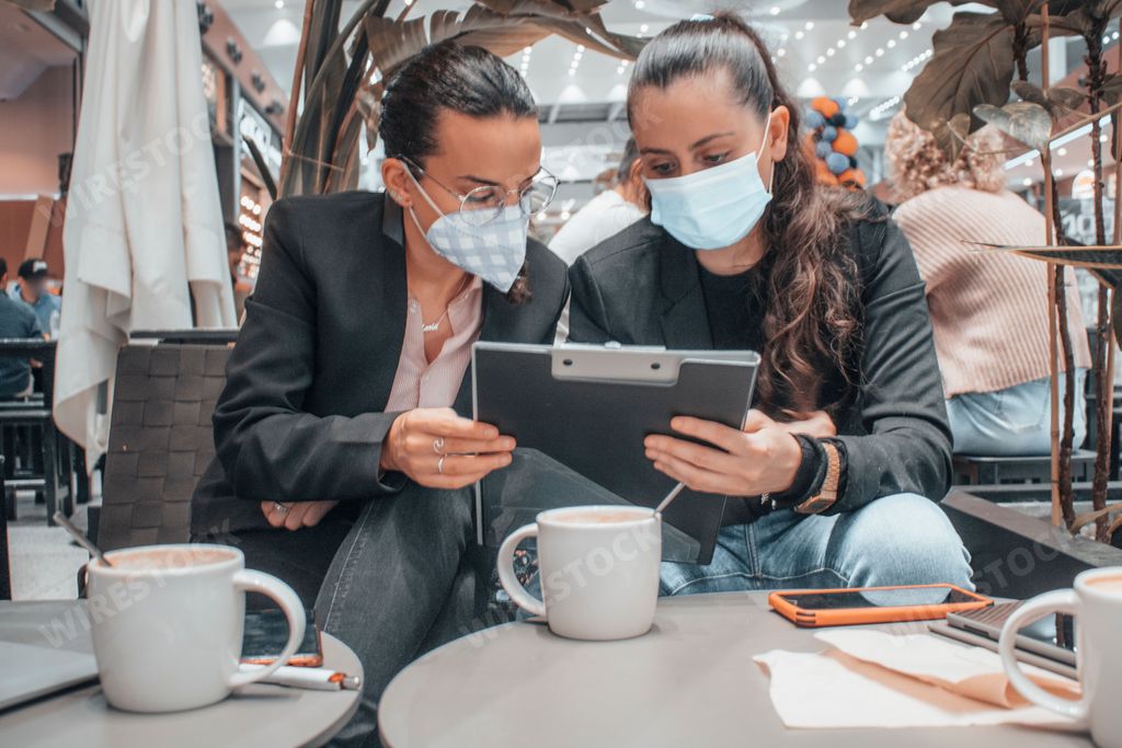 A closeup shot of two Spanish girls wearing masks and working together
