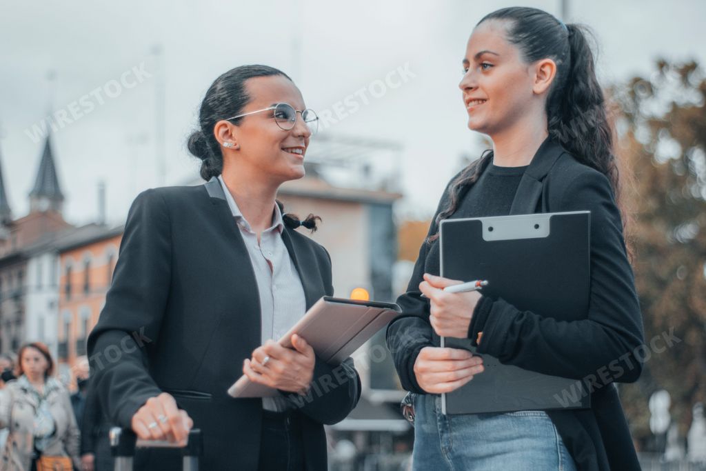The two attractive caucasian girls in formal style in the street.