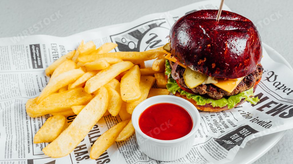 A closeup shot of a delicious burger with French fries and ketchup sauce