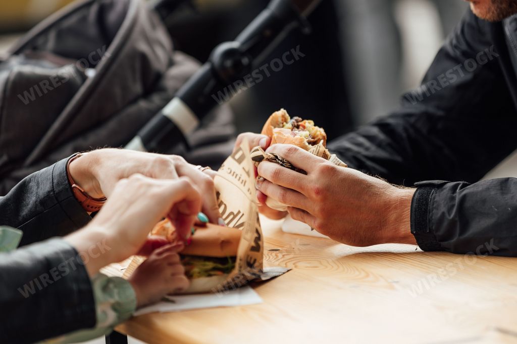 A man and woman eating burger at the festival food court