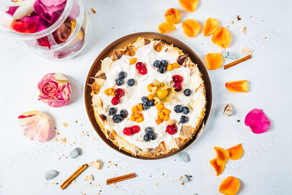 A delicious freshly baked cake with blackberries, sea buckthorns, and red currants