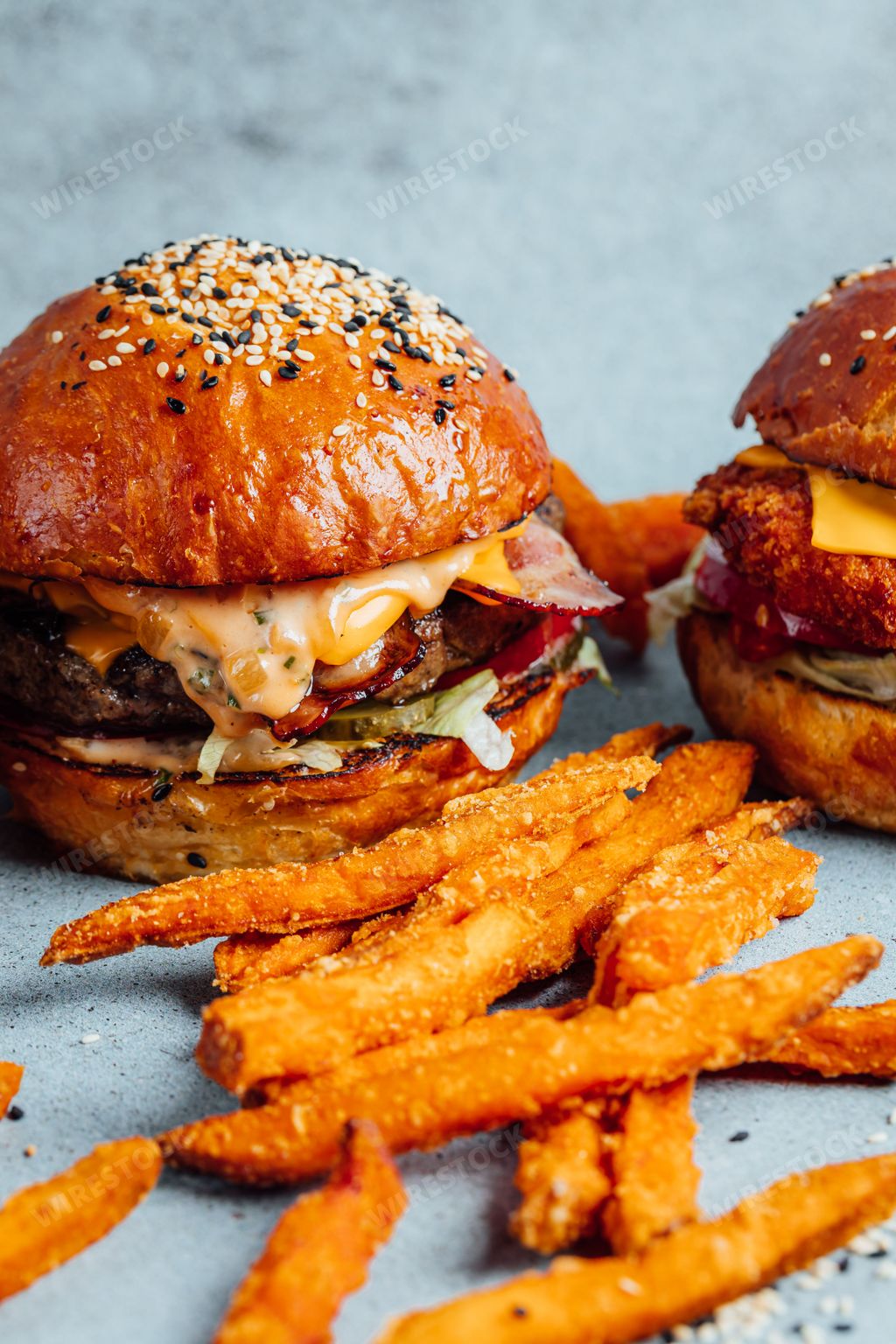 A vertical shot of the classic burgers on a bright background with fries