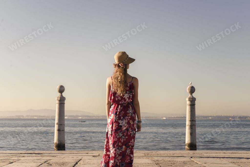 A landscape shot of a young female traveler enjoying the view of Praça do Comércio Lisbon Portugal