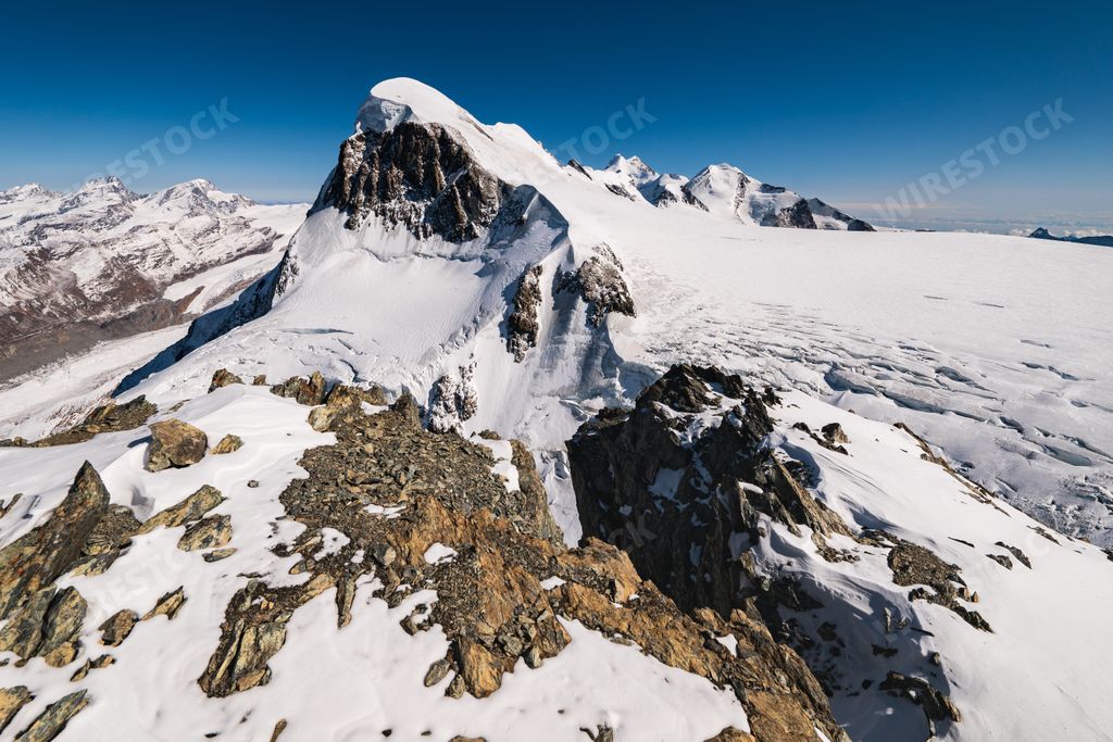 A breathtaking  shot of the snow-capped rocky mountains under a blue sky