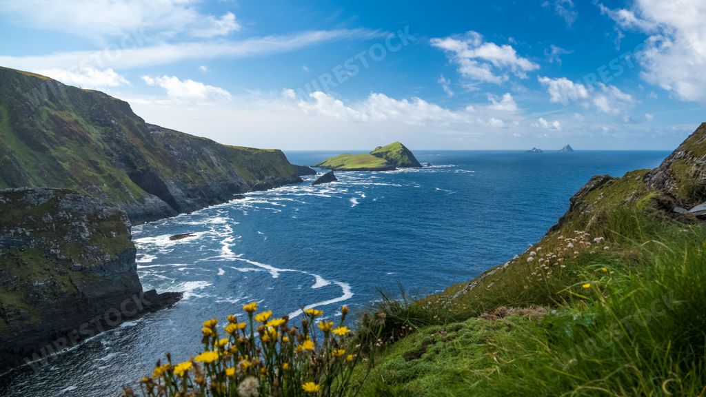 An aerial view of calm clear water and greenery-covered hills in Wicklow county town of Ireland